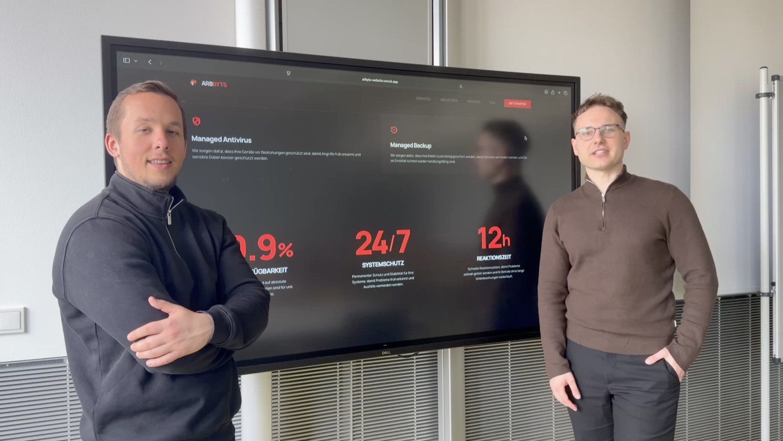 Andre Windmüller und Domenic Piras von AVIO im Gespräch vor einem Bildschirm mit Code